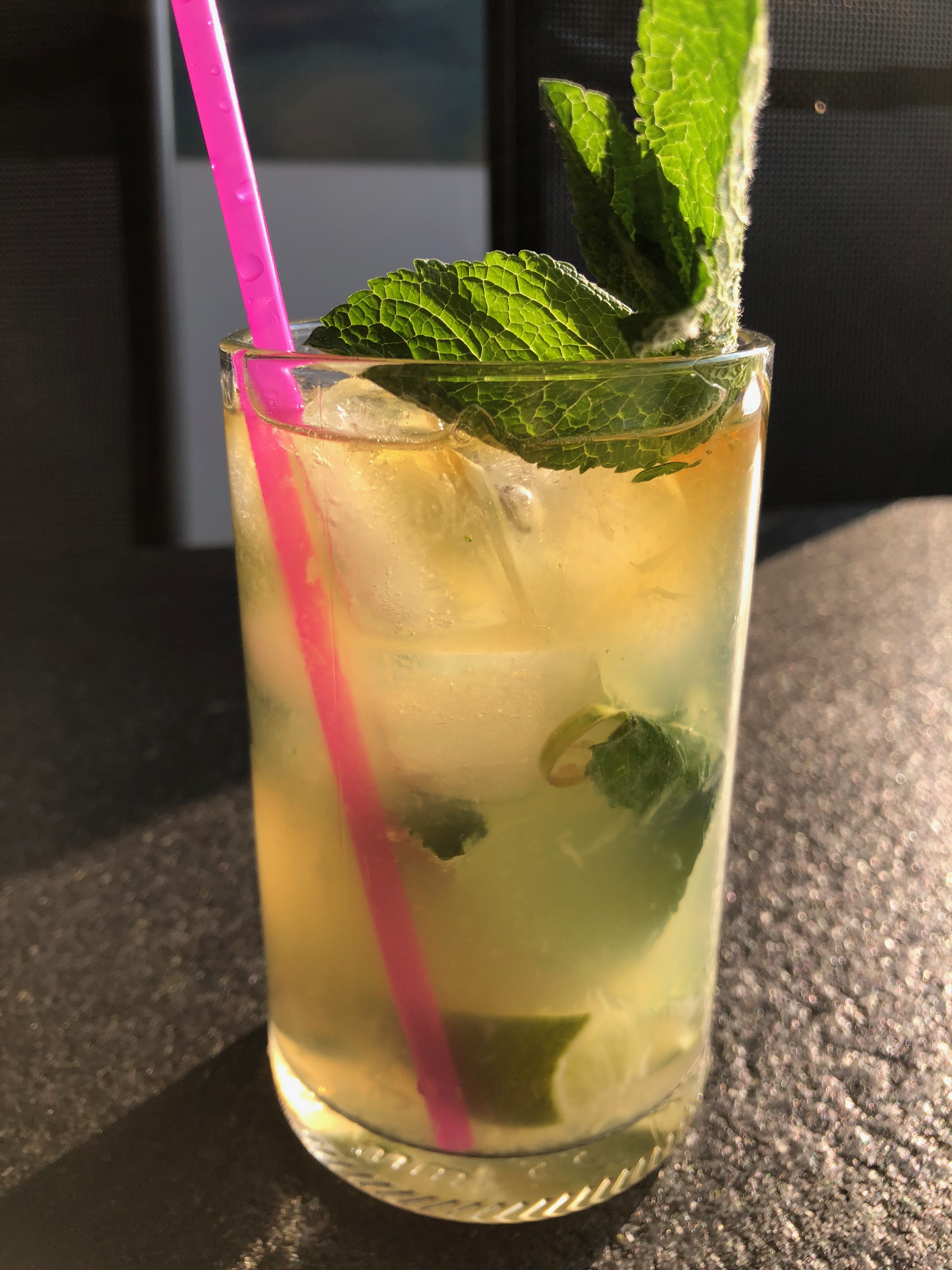 Frisse mojito met munt, limoen en transparant glas op een lichte tafel